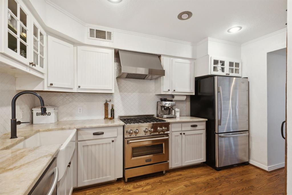 9427 Hobart Street Dallas, TX 75218 - Photo 6 of 25 a kitchen with stainless steel appliances a refrigerator stove and sink