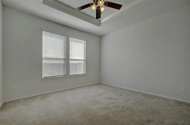 an empty room with a window and a fan
