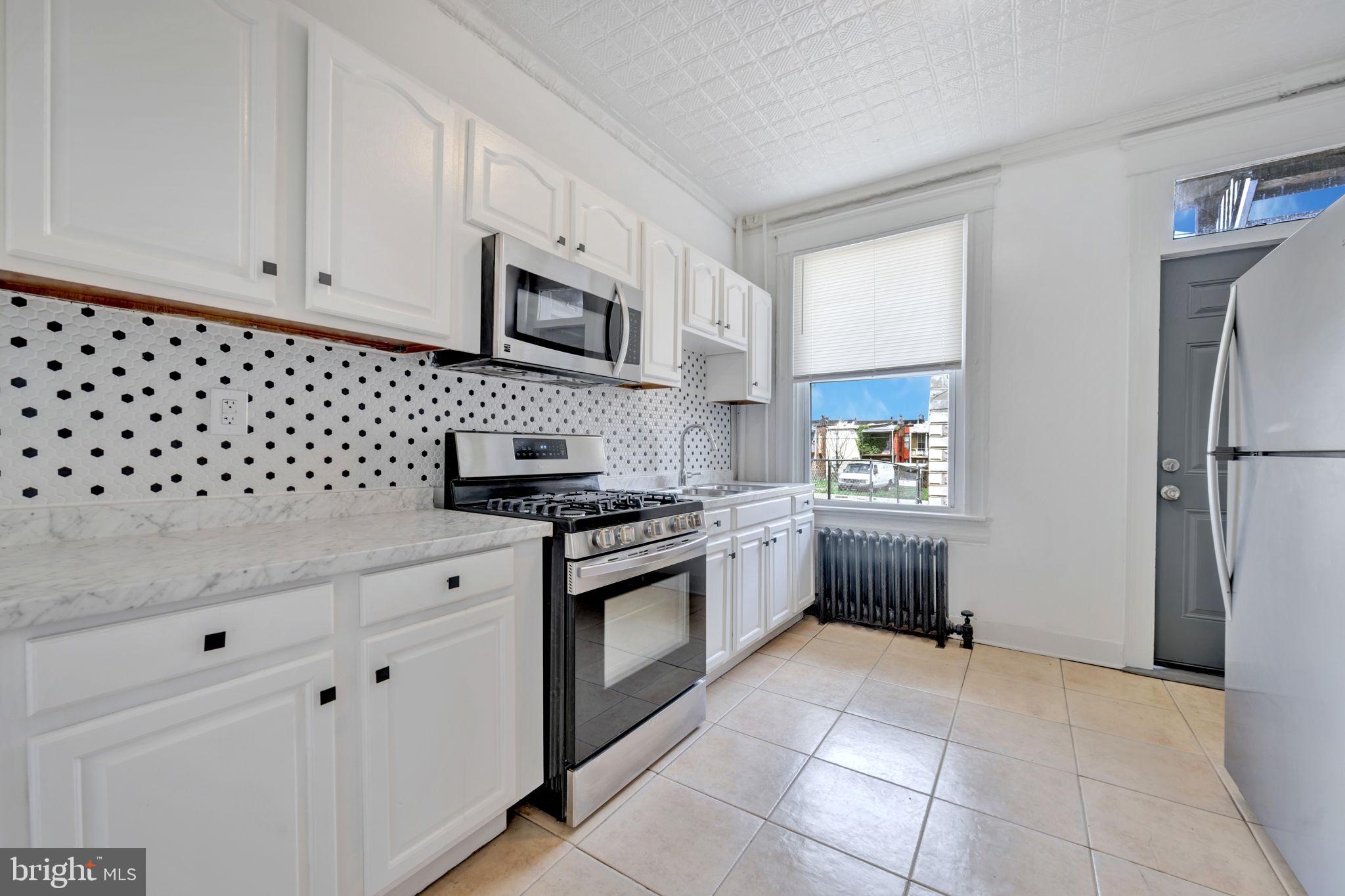 2822 Riggs Avenue Baltimore, MD 21216 - Photo 13 of 30 a kitchen with granite countertop a sink stove and refrigerator