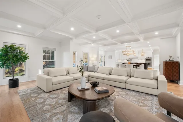 a living room with furniture potted plant and kitchen view