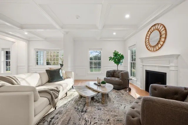 a living room with furniture a fireplace and a large window