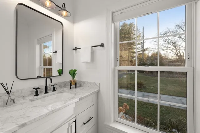 a bathroom with a granite countertop sink mirror and vanity