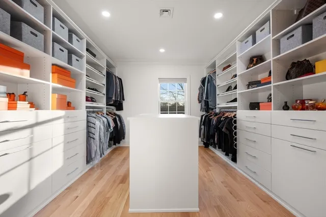 a view of walk in closet with clothes and shoes