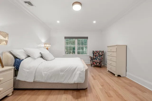 a spacious bedroom with a bed and a dresser