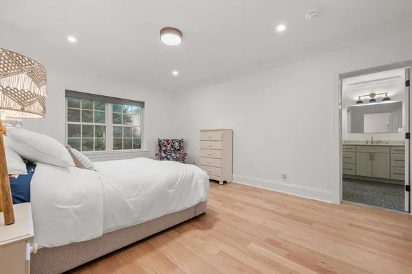a large white bed sitting in a room next to a window