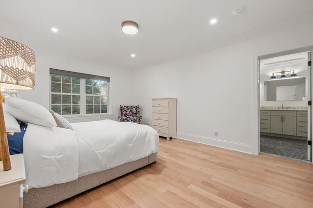 a large white bed sitting in a room next to a window