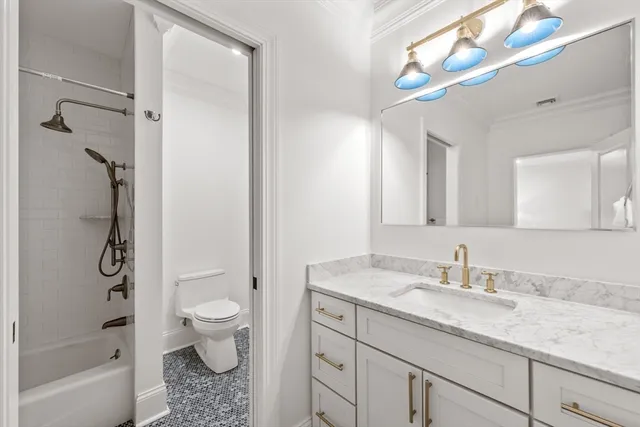 a bathroom with a granite countertop sink a toilet and shower