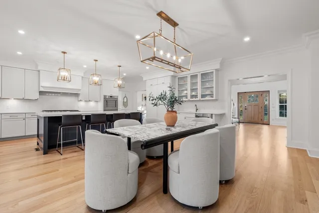 a kitchen with granite countertop a table chairs a sink dishwasher refrigerator and cabinets