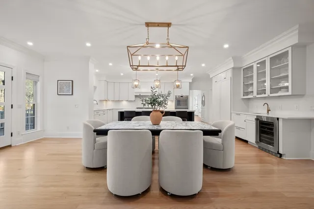 a living room with furniture a chandelier and kitchen view