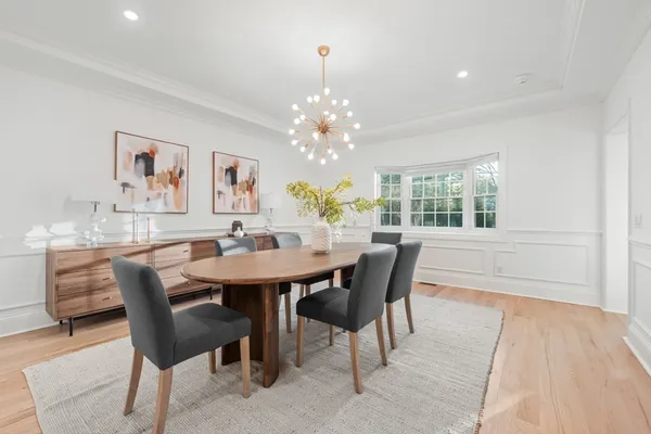 a dining room with furniture a rug and a chandelier