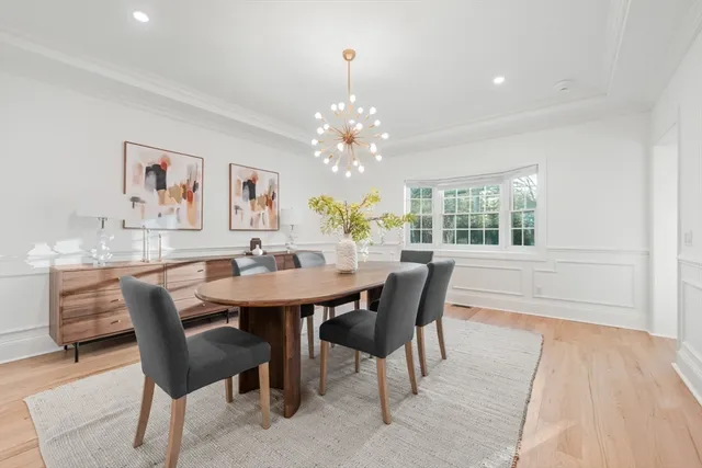 a dining room with furniture a rug and a chandelier