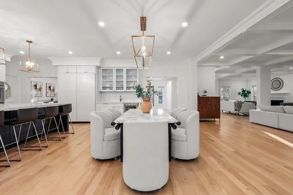 a very nice looking dining room with kitchen island furniture a wooden floor and a sink