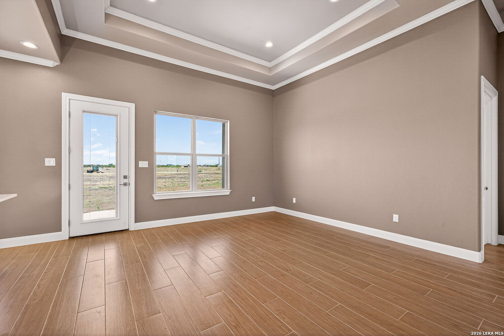 123 John T Court Castroville, TX 78009 - Photo 16 of 45 a view of an empty room with wooden floor and a window