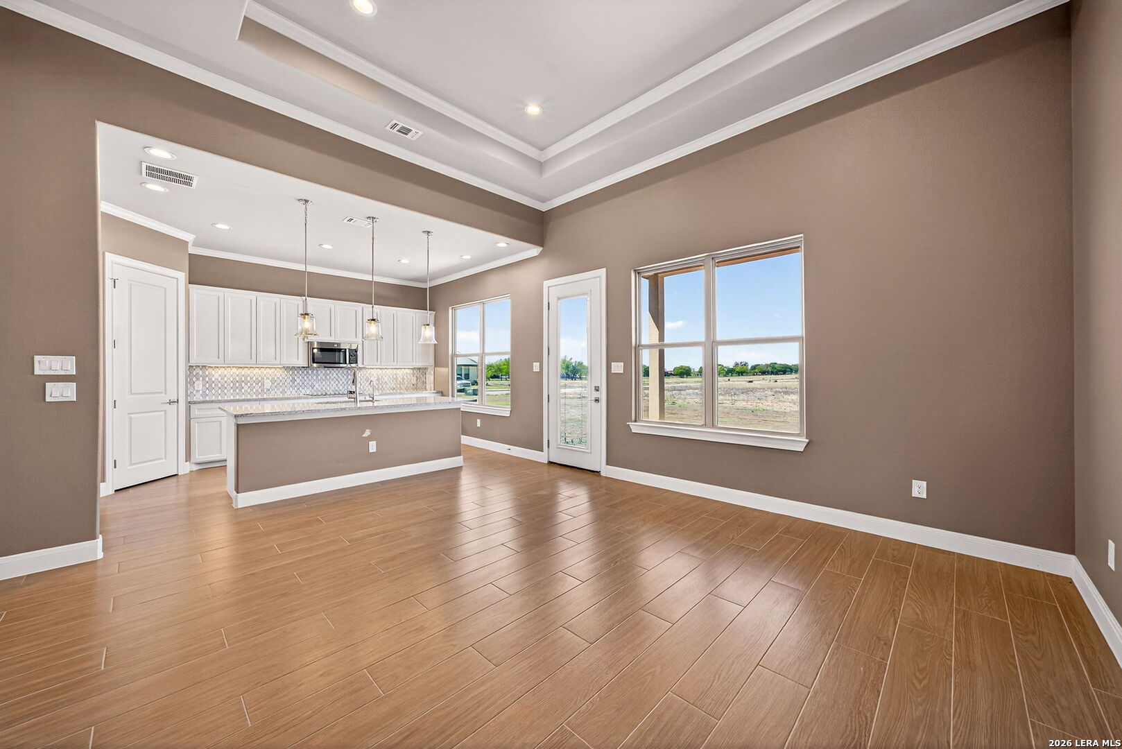 123 John T Court Castroville, TX 78009 - Photo 17 of 45 a view of an empty room with window and wooden floor