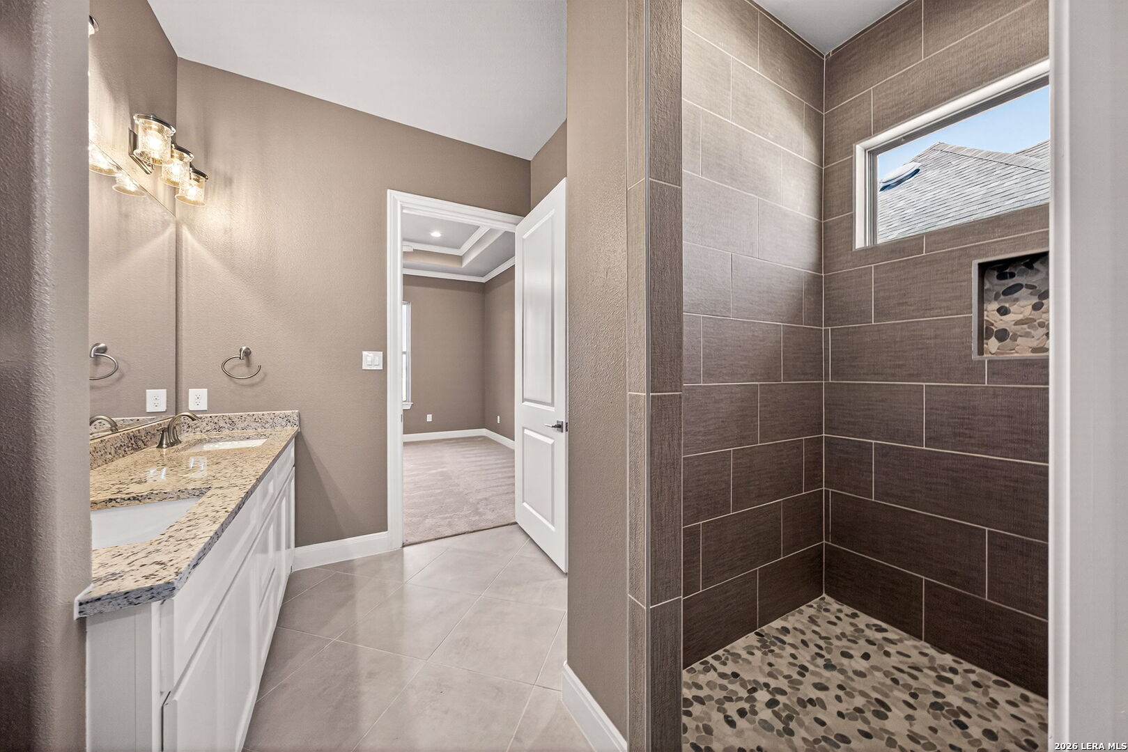 123 John T Court Castroville, TX 78009 - Photo 23 of 45 a bathroom with a granite countertop sink a mirror and a shower