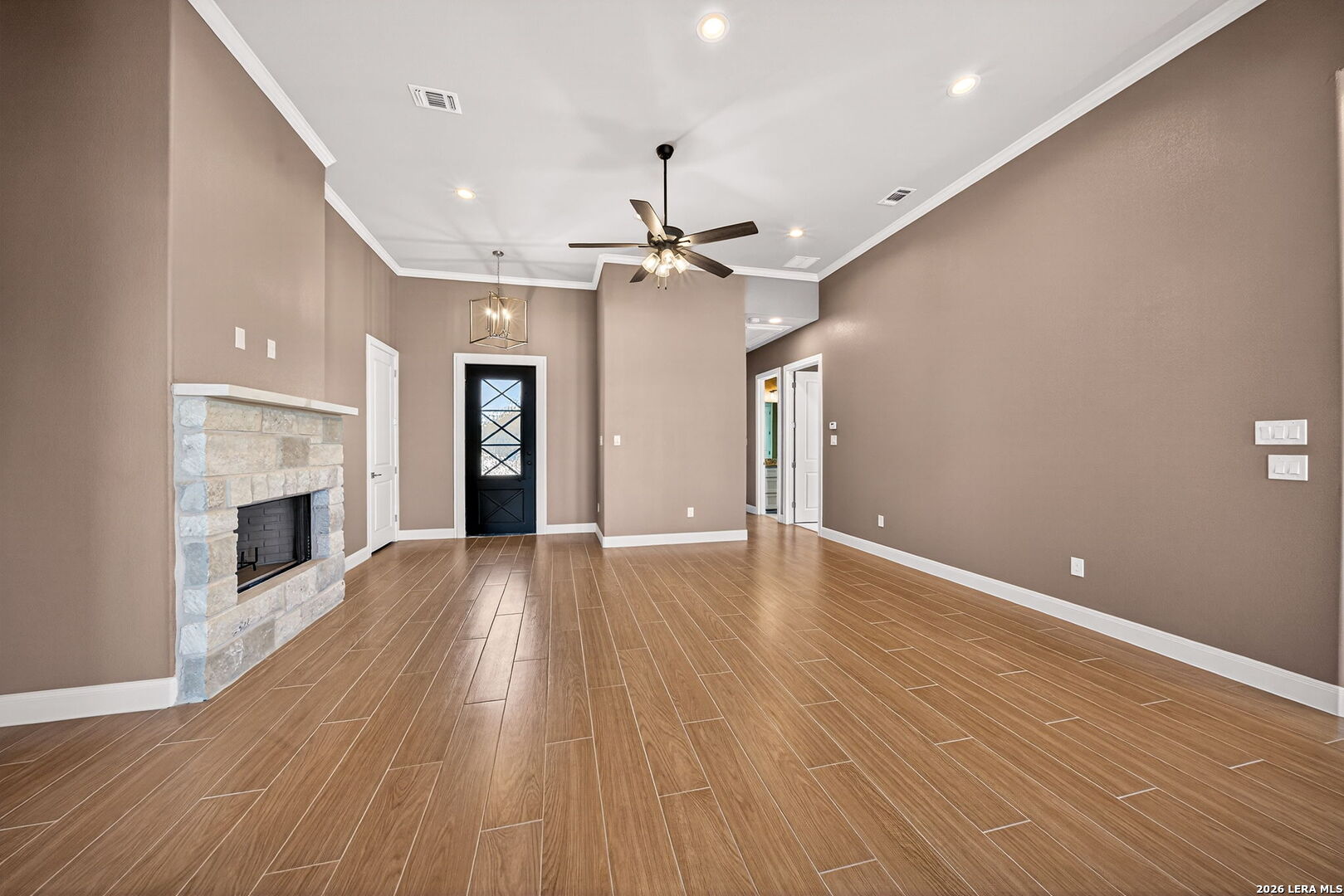 123 John T Court Castroville, TX 78009 - Photo 10 of 45 an empty room with wooden floor fireplace and windows