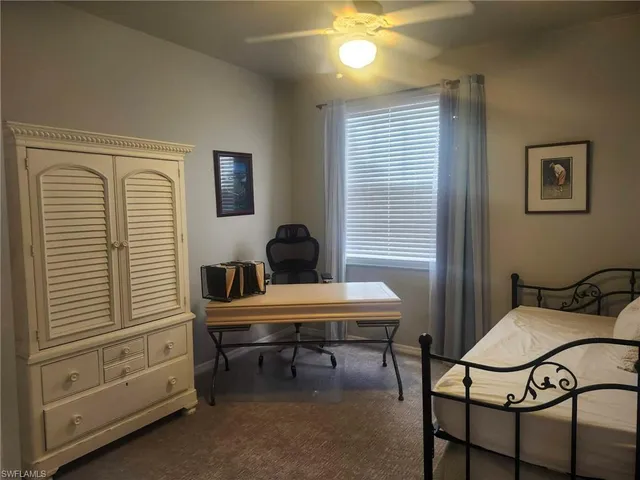 a view of a workspace with furniture and a window