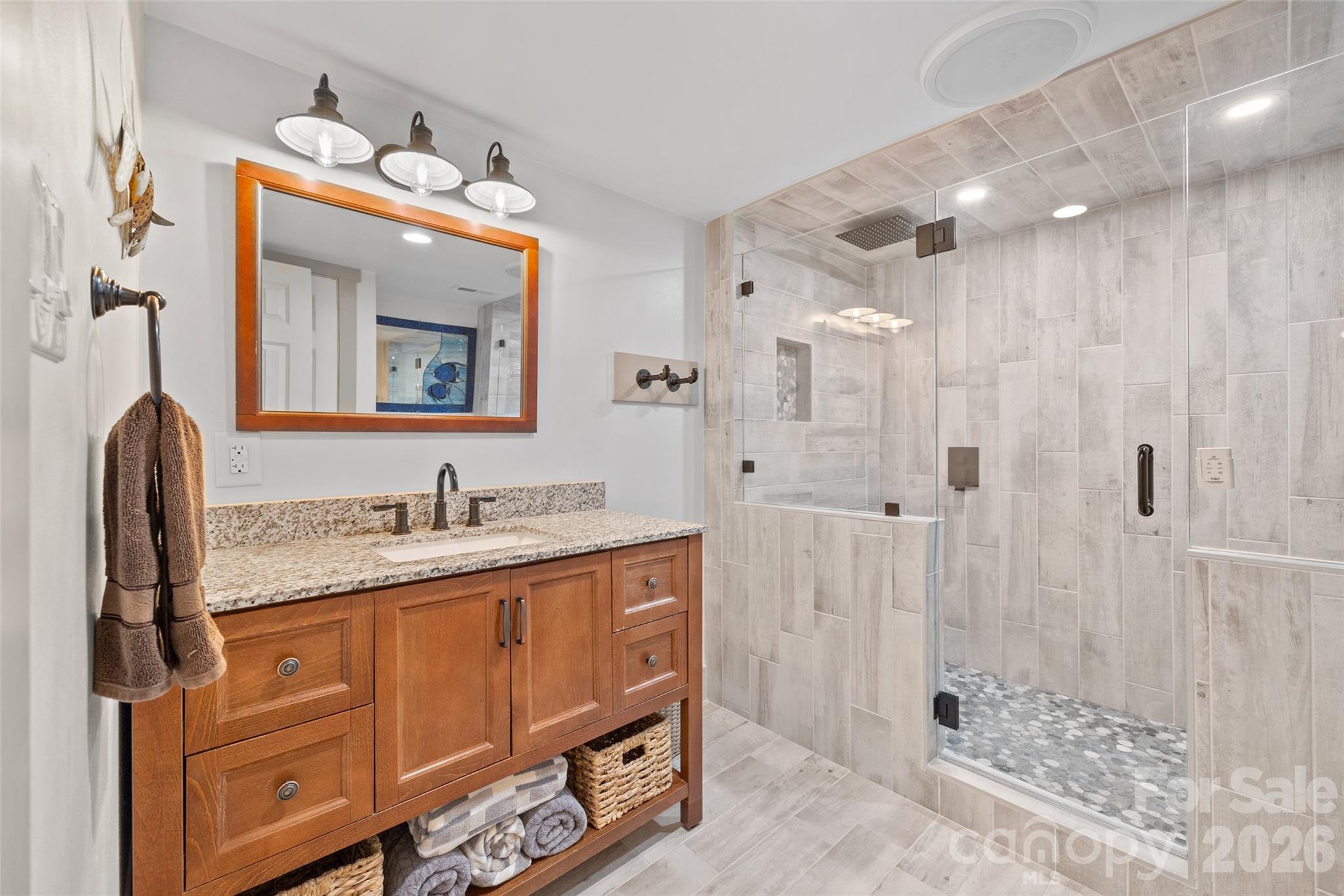 27056 Catamaran Drive Tega Cay, SC 29708 - Photo 30 of 48 a bathroom with a granite countertop sink a mirror a vanity and shower