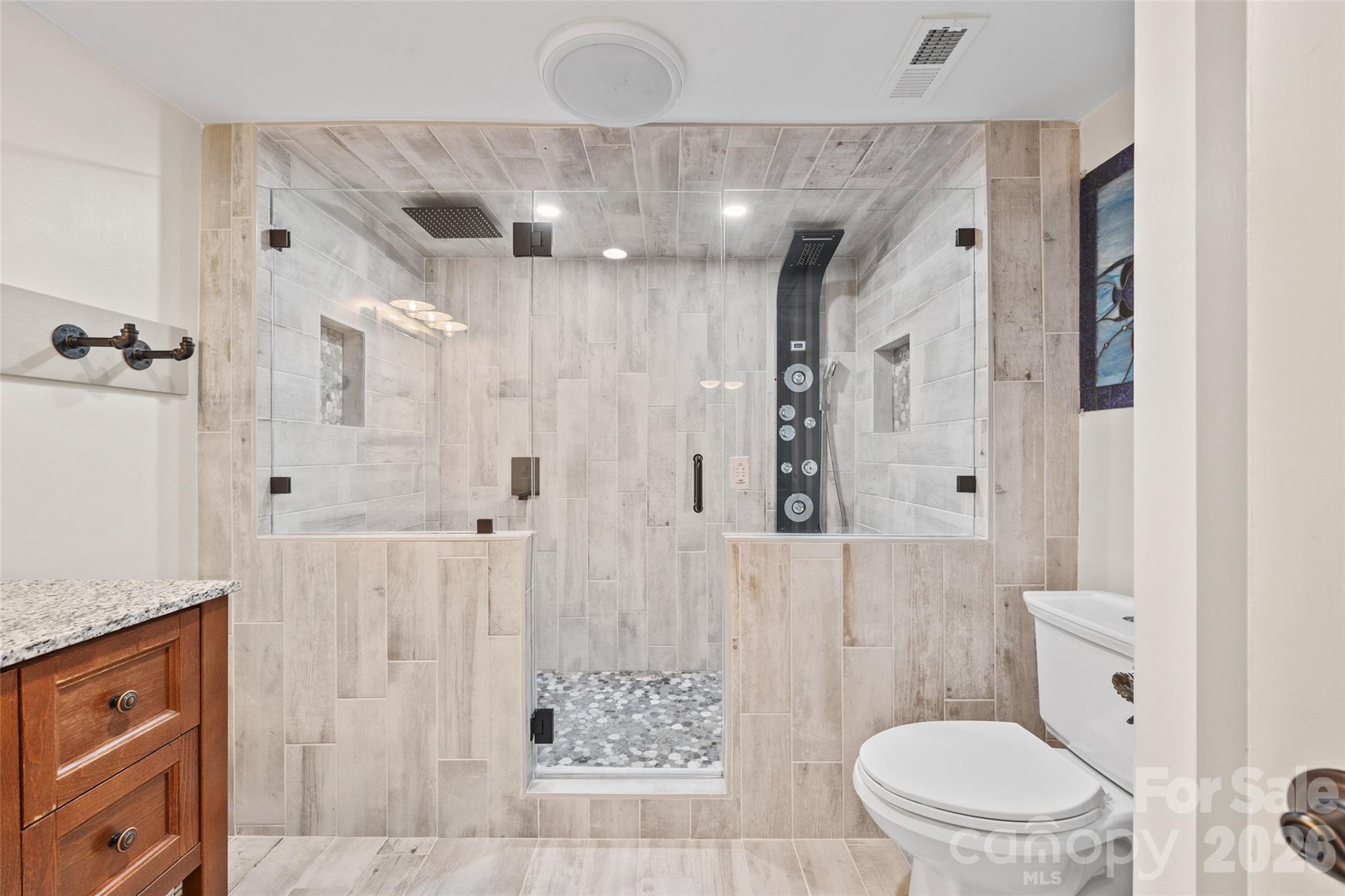 27056 Catamaran Drive Tega Cay, SC 29708 - Photo 31 of 48 a bathroom with a granite countertop sink a toilet a shower and a mirror