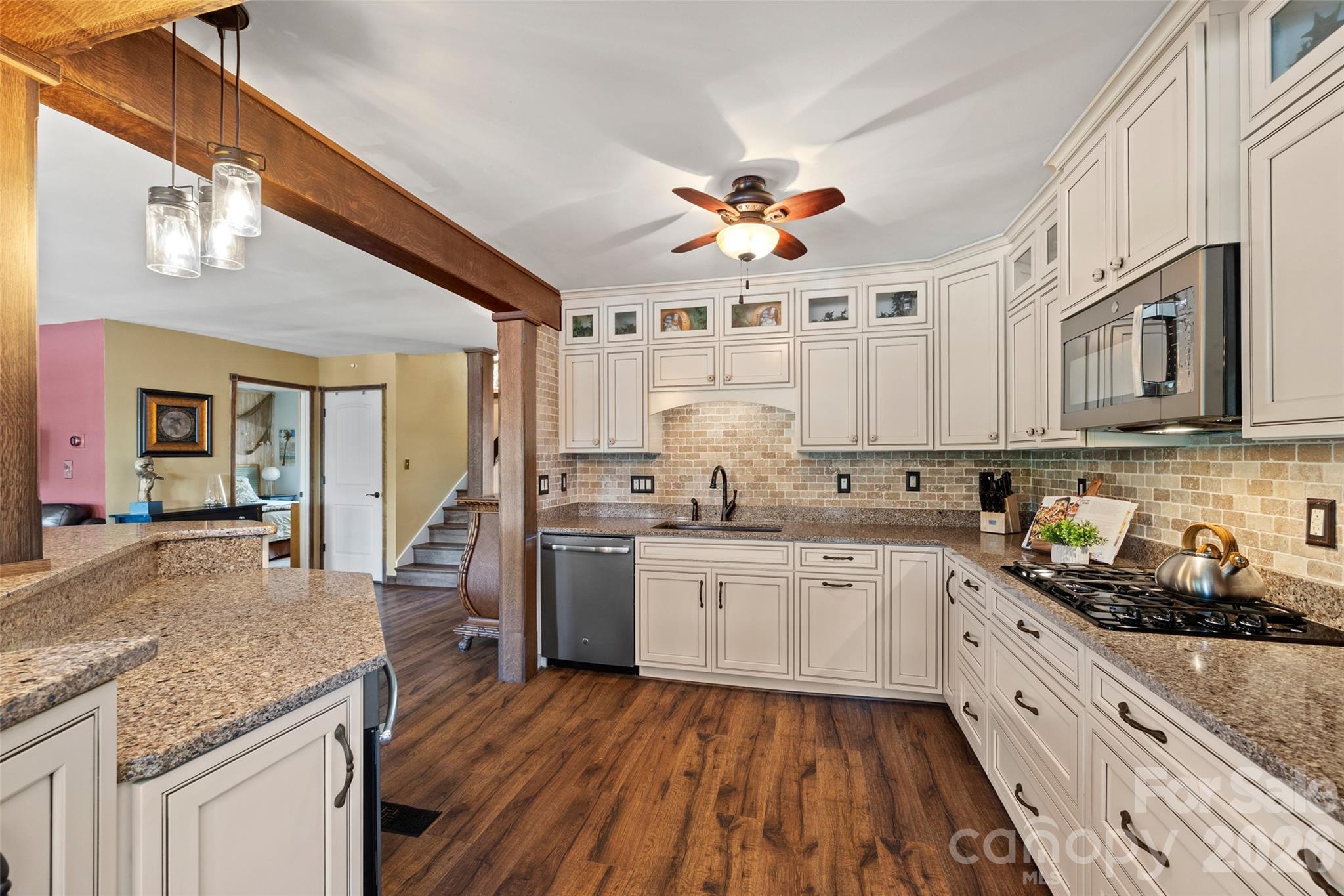 27056 Catamaran Drive Tega Cay, SC 29708 - Photo 8 of 48 a kitchen with stainless steel appliances granite countertop hardwood floor sink stove dining table and chairs