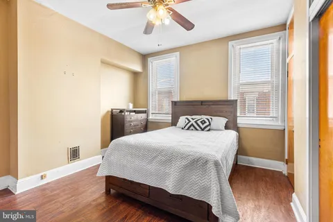 a bedroom with a bed and wooden floor