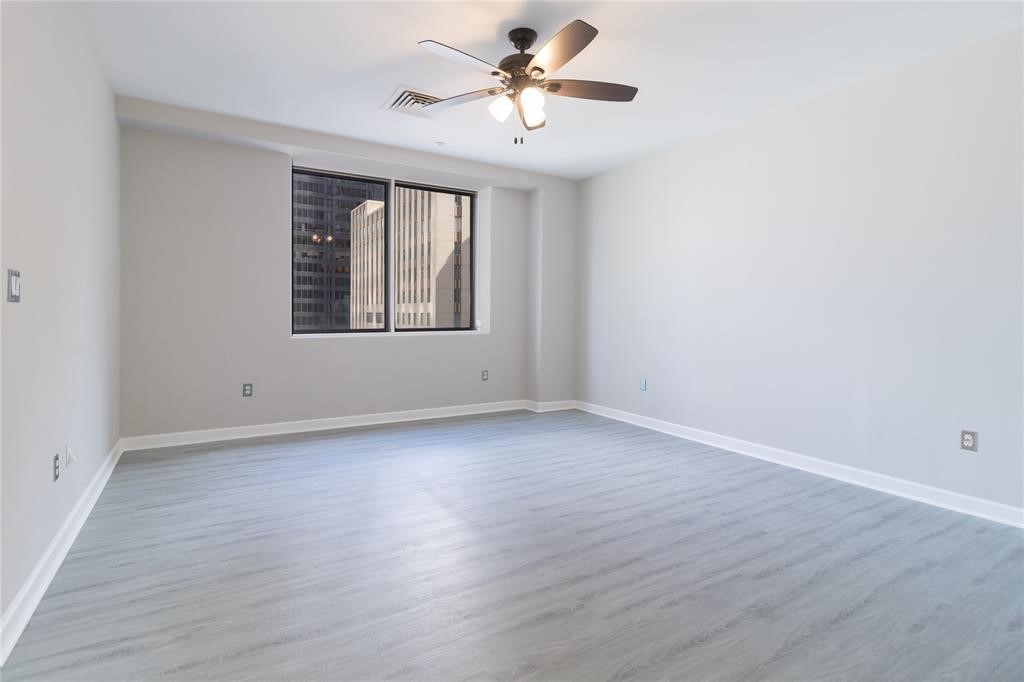 914 Main Street, Unit 1503 Houston, TX 77002 - Photo 8 of 33 a view of a room with wooden floor and a ceiling fan
