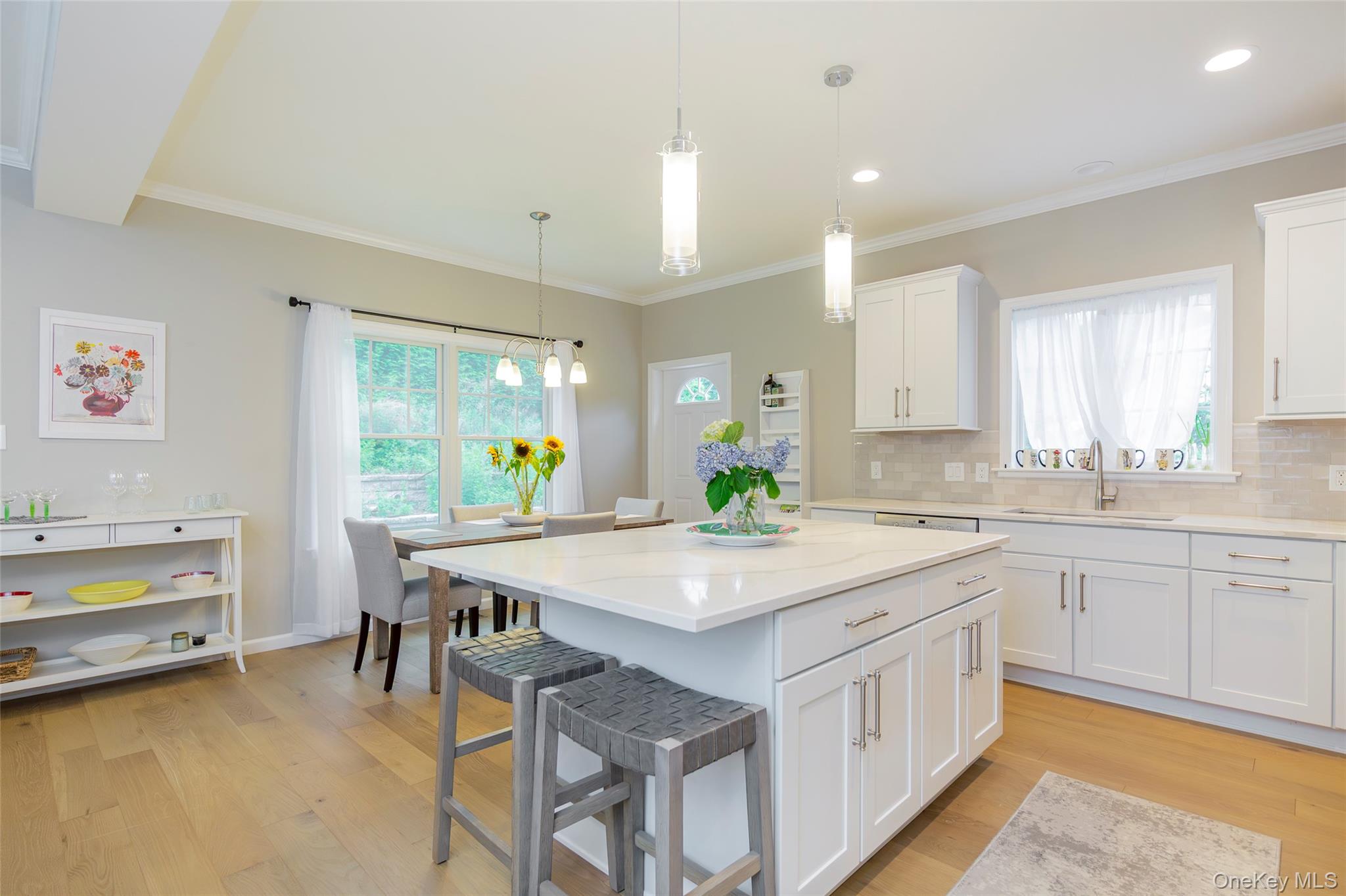 15 South Beach Road Southampton, NY 11968 - Photo 16 of 28 a kitchen with a stove a sink a dining table and chairs
