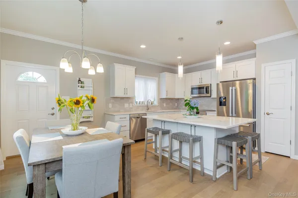 a kitchen with kitchen island white cabinets and stainless steel appliances