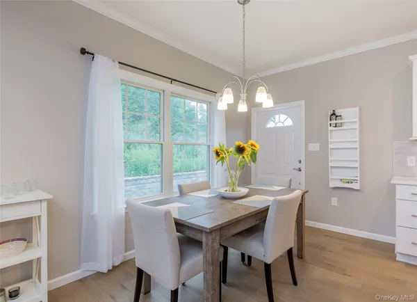 a dining room with furniture a potted plant and a chandelier