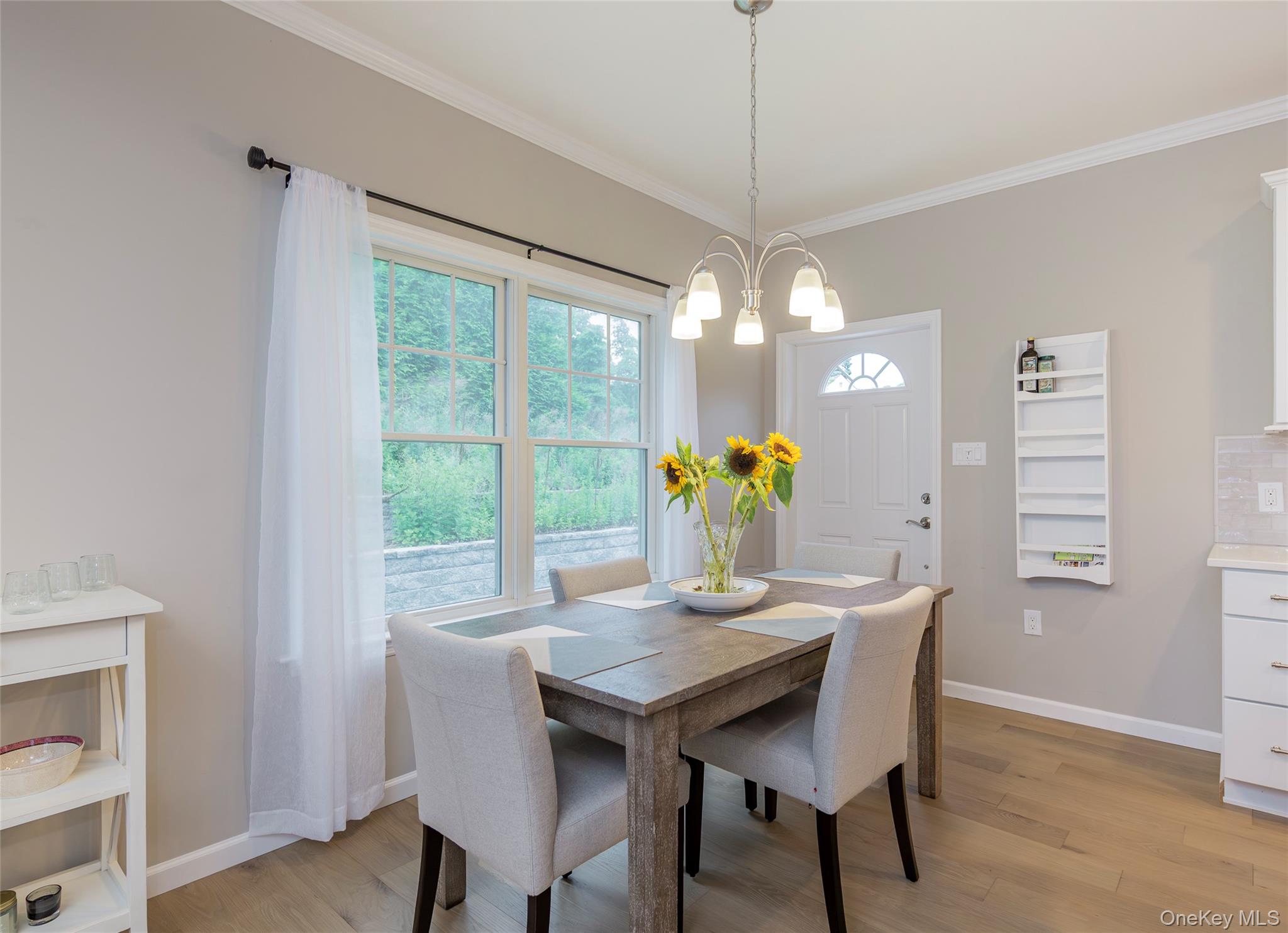 15 South Beach Road Southampton, NY 11968 - Photo 18 of 28 a dining room with furniture a potted plant and a chandelier