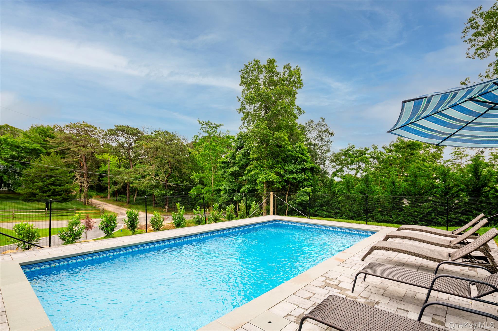 15 South Beach Road Southampton, NY 11968 - Photo 2 of 28 a view of a swimming pool with a yard