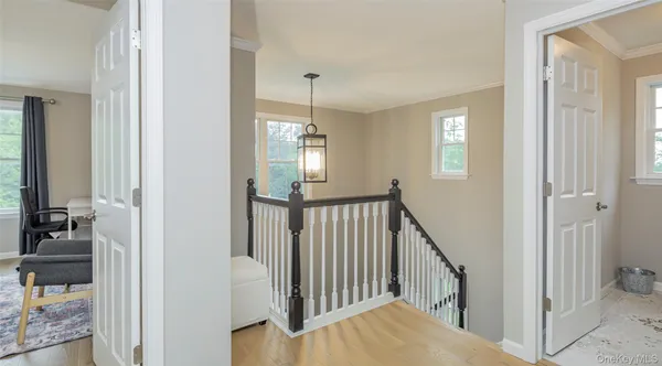a view of a hallway with a dining room and chandelier fan