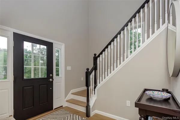 a view of a hallway with wooden floor and stairs