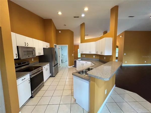 a kitchen with stainless steel appliances granite countertop a sink a stove and a refrigerator