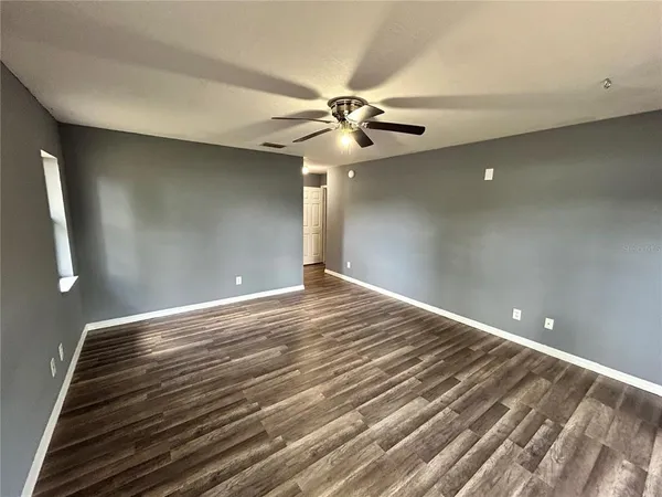 a view of empty room with wooden floor