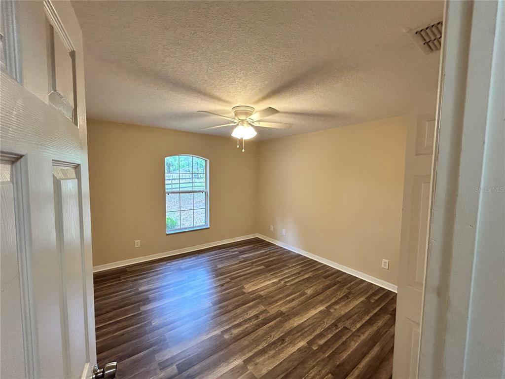 4475 Southwest 115th Street Ocala, FL 34476 - Photo 22 of 35 a view of an empty room with window and wooden floor