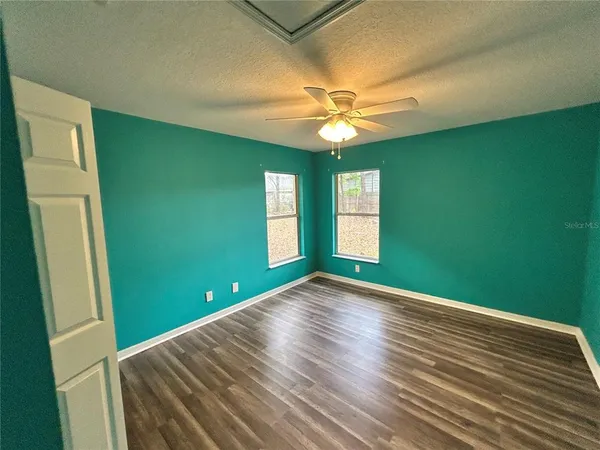 a view of empty room with window and fan