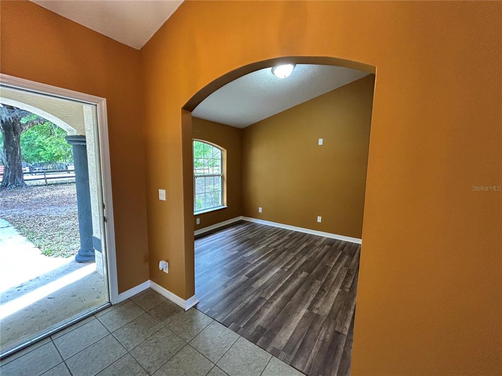 4475 Southwest 115th Street Ocala, FL 34476 - Photo 7 of 35 an empty room with wooden floor and windows