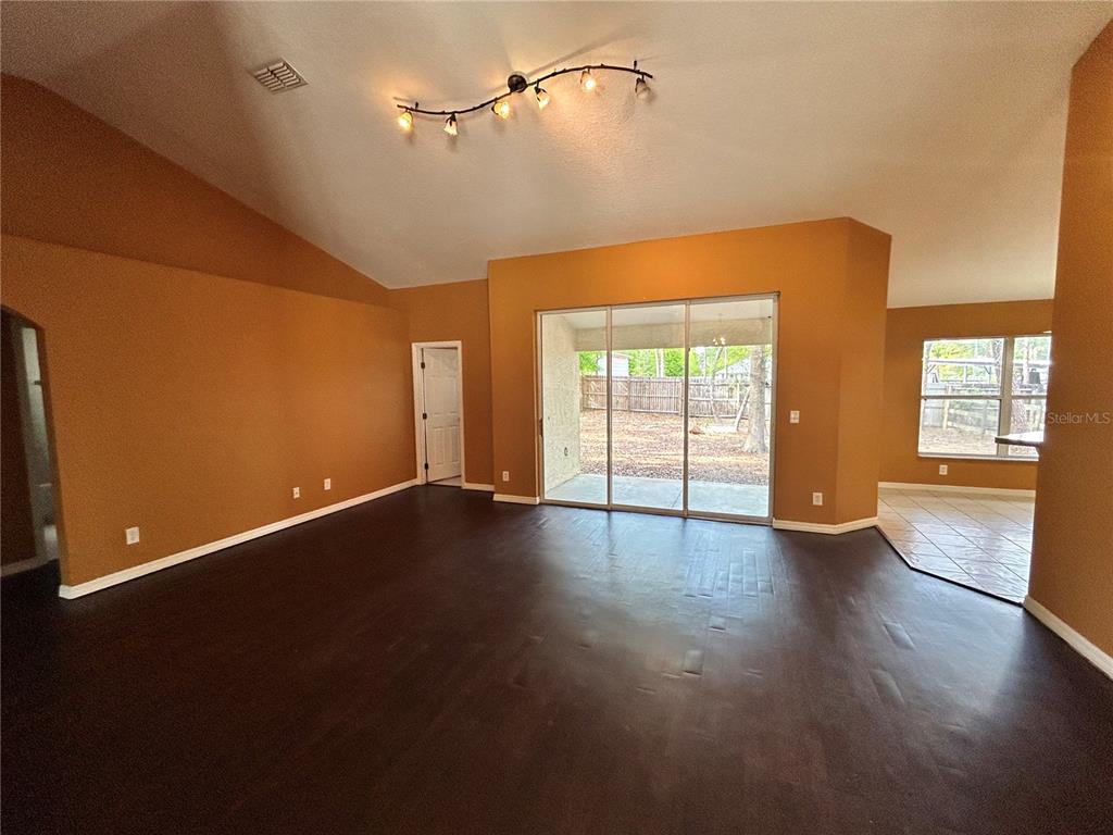 4475 Southwest 115th Street Ocala, FL 34476 - Photo 9 of 35 an empty room with wooden floor and windows
