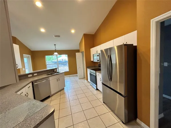 a kitchen with stainless steel appliances granite countertop a refrigerator and a sink