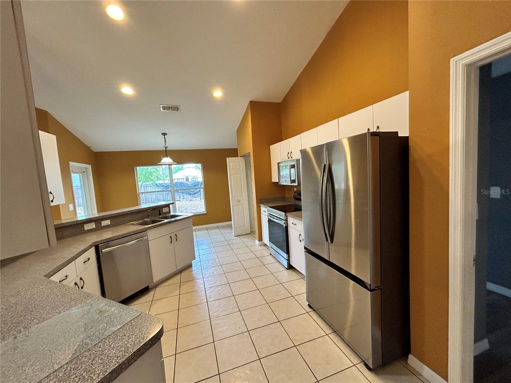 4475 Southwest 115th Street Ocala, FL 34476 - Photo 10 of 35 a kitchen with stainless steel appliances granite countertop a refrigerator and a sink