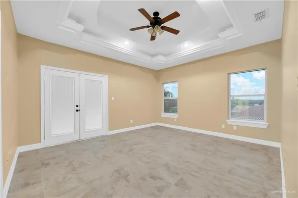 an empty room with windows and fan
