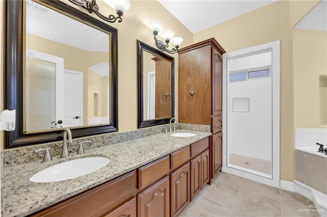 a spacious bathroom with a granite countertop double vanity sink and a mirror