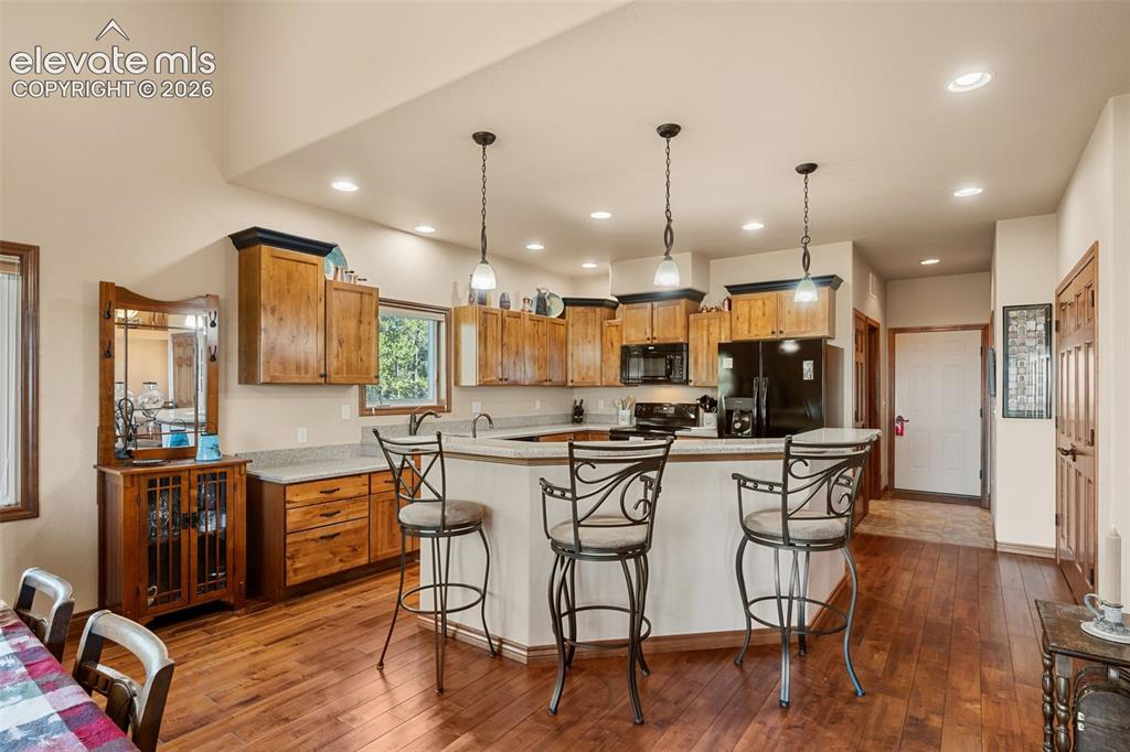 131 Paradiso Road Divide, CO 80814 - Photo 18 of 50 a kitchen with stainless steel appliances kitchen island granite countertop a stove a sink a refrigerator and chairs with wooden floor
