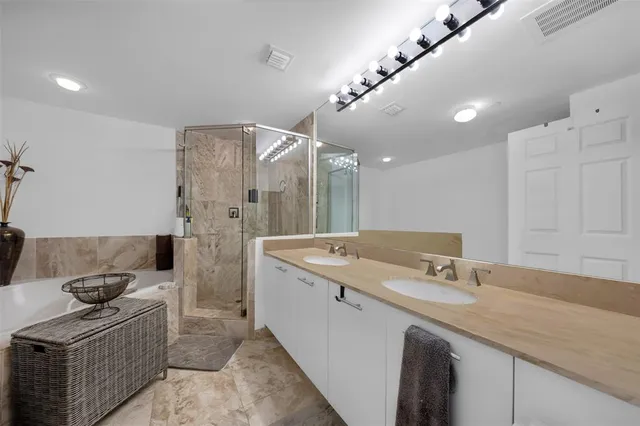 a spacious bathroom with a sink a large mirror and shower