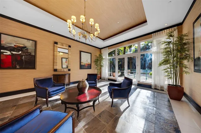 a living room with furniture a flat screen tv and a large window