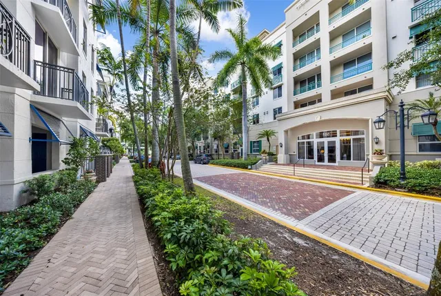 a view of a building with a yard and potted plants