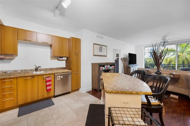 a living room with stainless steel appliances granite countertop furniture and a kitchen view