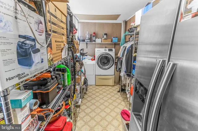 a utility room with dryer washer and a view of living room