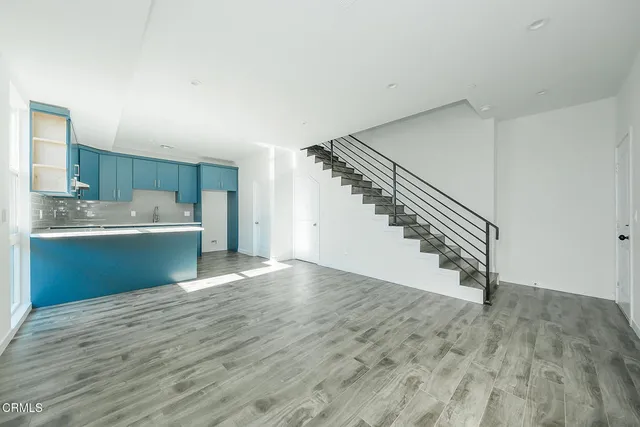 a view of a kitchen with wooden floor and staircase